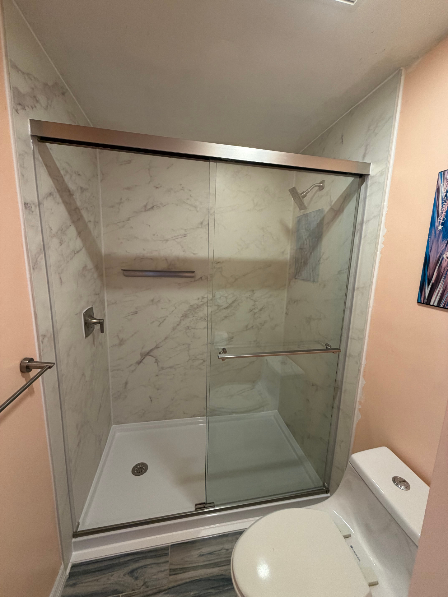 Semi-frameless glass shower with Carrara marble-look walls